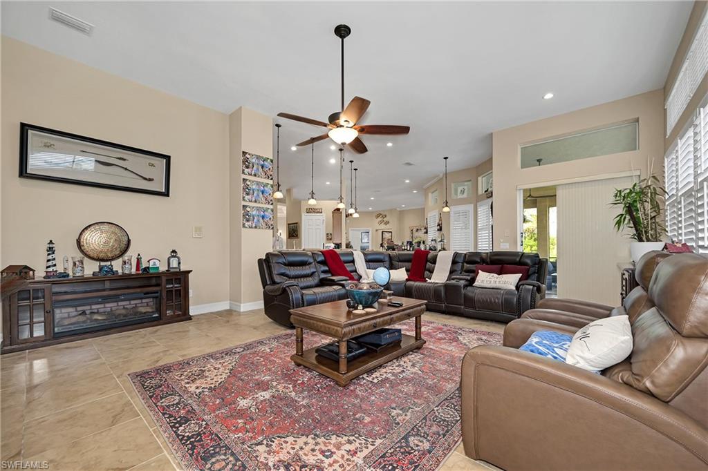 Living area with a ceiling fan, healthy amount of natural light, recessed lighting, and light tile patterned floors