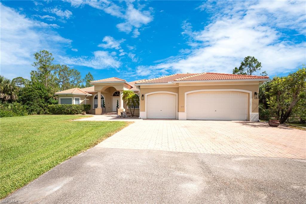 Mediterranean / spanish house featuring stucco siding, decorative driveway, a front lawn, an attached garage, and a tile roof