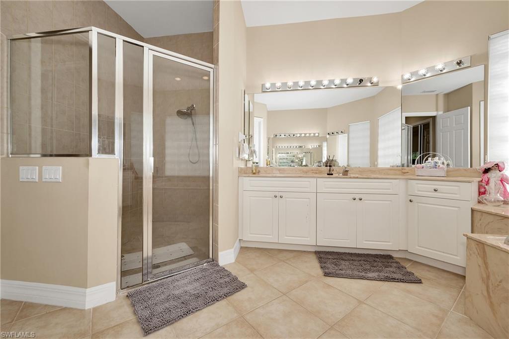 Full bath featuring a shower stall, vanity, and tile patterned flooring