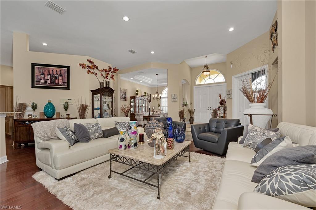 Living area featuring wood finished floors, arched walkways, recessed lighting, and a chandelier