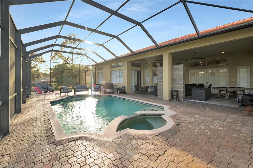 View of swimming pool featuring a patio, a pool with connected hot tub, an outdoor hangout area, a ceiling fan, and a lanai