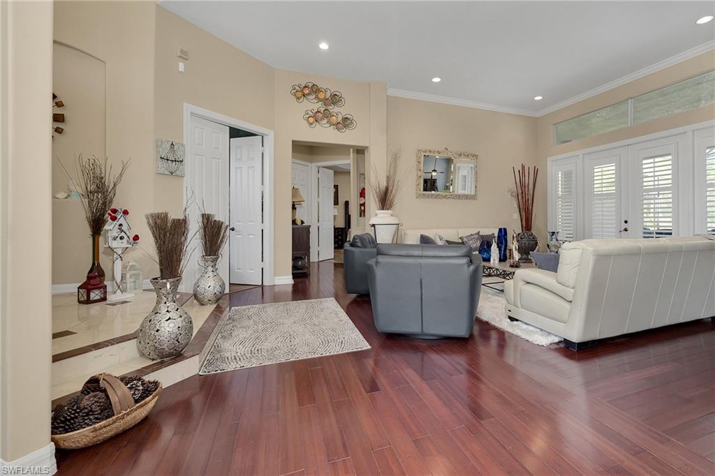 Living area featuring wood finished floors, crown molding, and recessed lighting