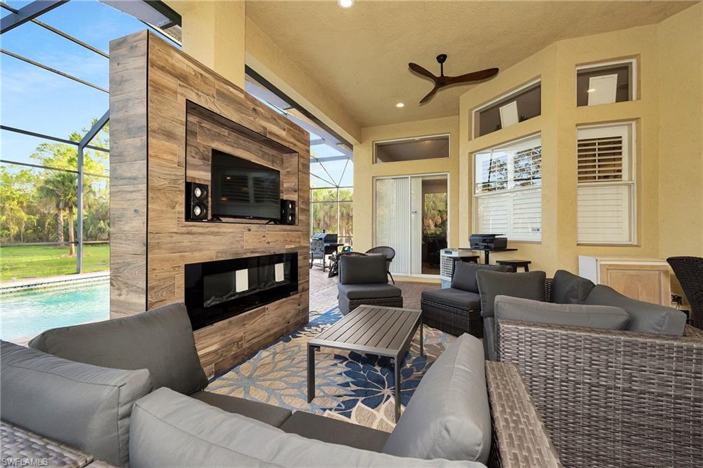 View of patio with an outdoor hangout area, a ceiling fan, glass enclosure, and an outdoor pool