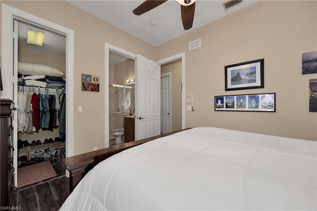 Bedroom with a closet, ensuite bathroom, wood finished floors, and a ceiling fan