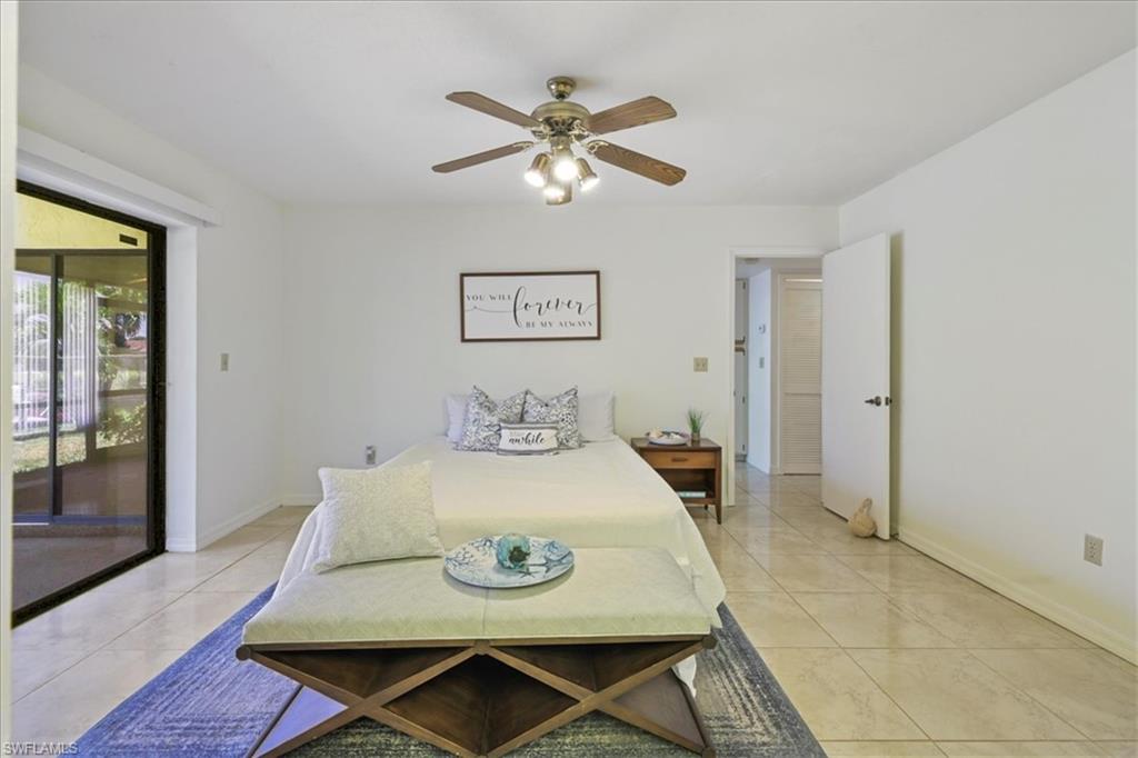 Full bath featuring ceiling fan, a tile shower, a skylight, double vanity, and tile patterned floors