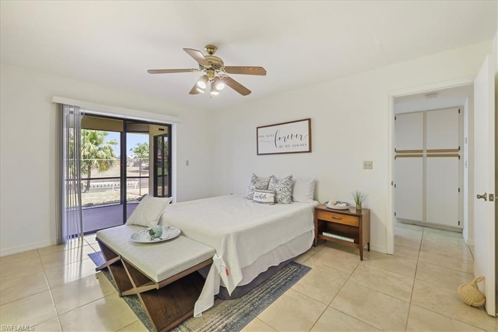 Bedroom featuring access to outside, baseboards, light tile patterned flooring, and a ceiling fan