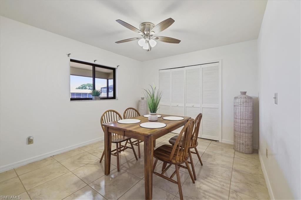 Dining space featuring a ceiling fan, baseboards, and light tile patterned flooring