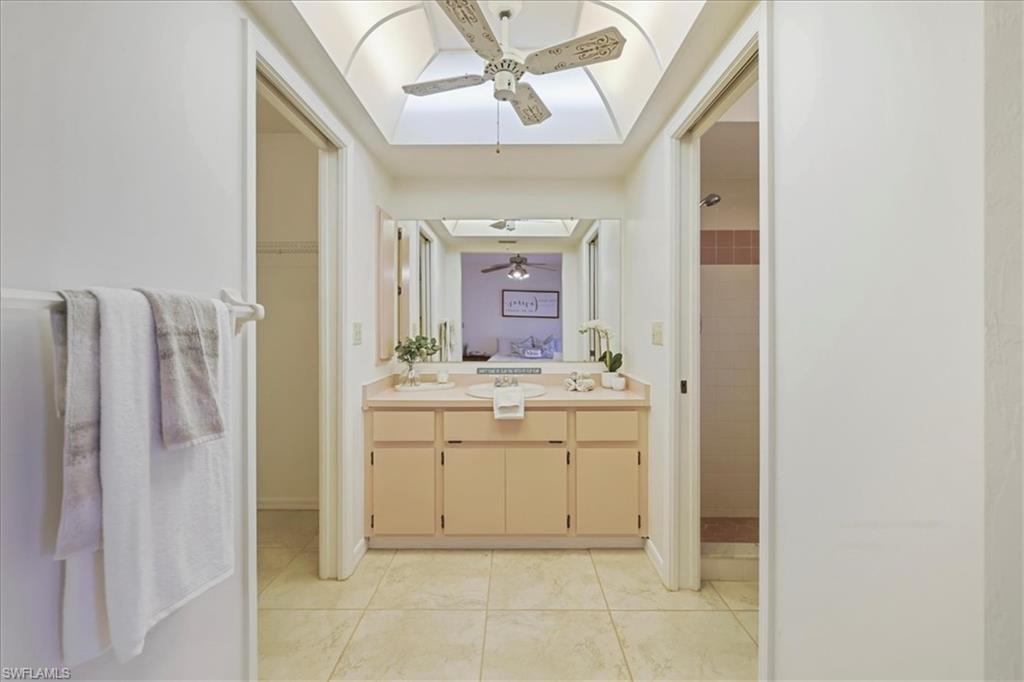 Unfurnished sunroom with ceiling fan, a water view, and a residential view