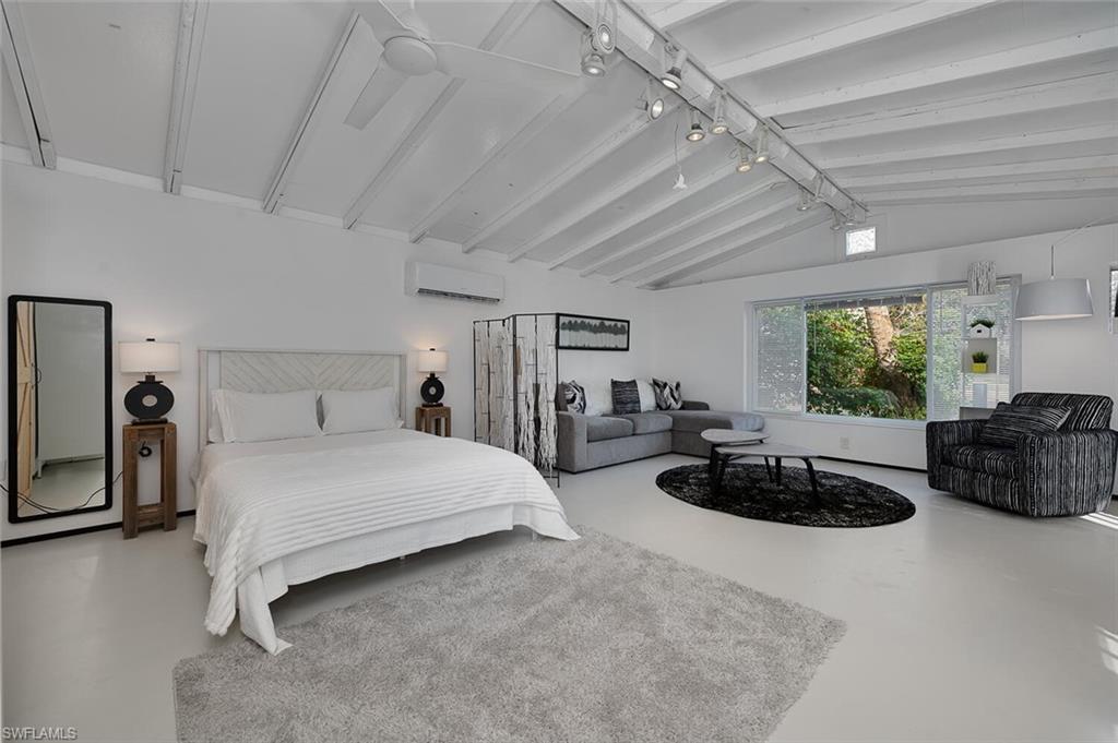 Bedroom with a wall mounted air conditioner and concrete flooring