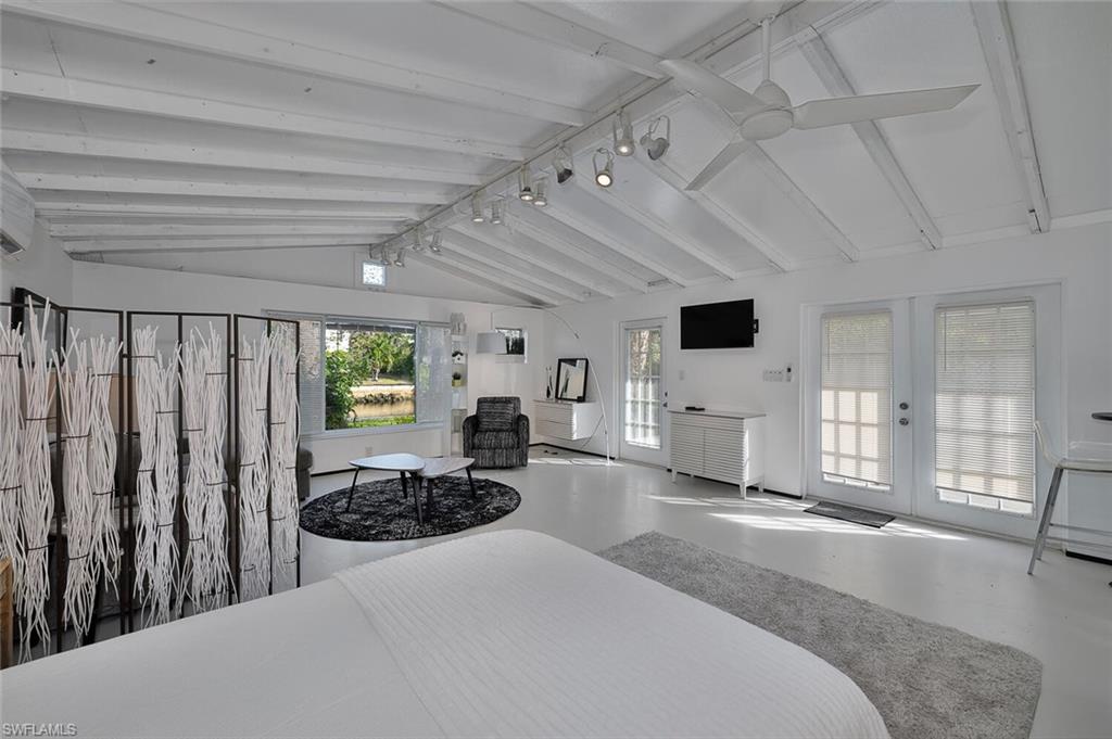 Bedroom featuring access to outside, concrete flooring, and french doors