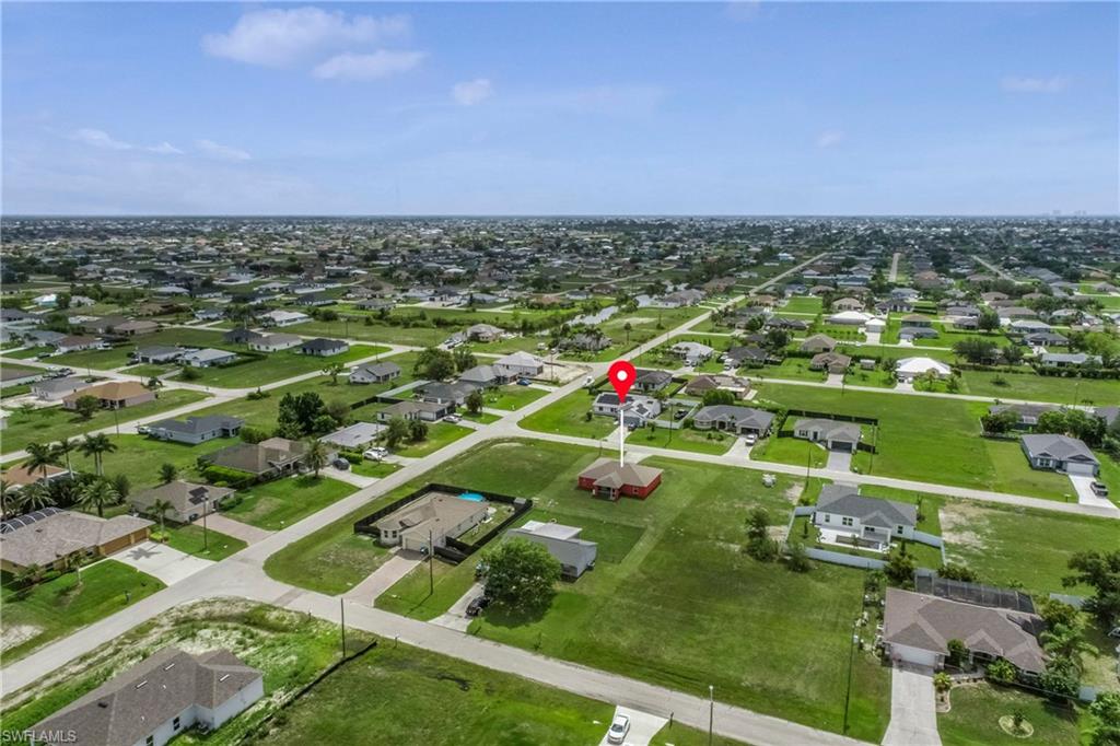 Aerial view of property and surrounding area with nearby suburban area