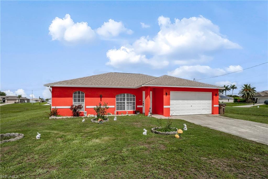 Ranch-style home featuring an attached garage, driveway, and a front yard