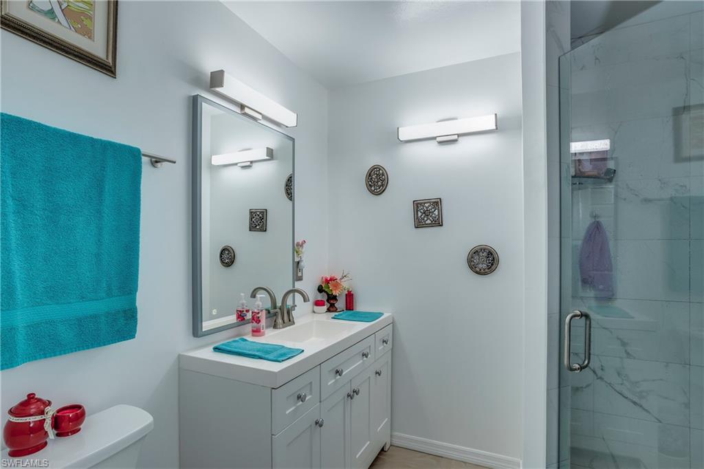 Bathroom with vanity, a stall shower, and toilet