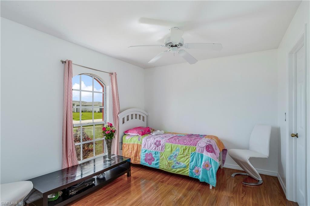 Bedroom with wood finished floors, ceiling fan, and baseboards