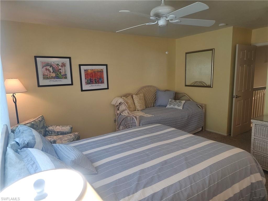 Carpeted bedroom featuring ceiling fan and baseboards