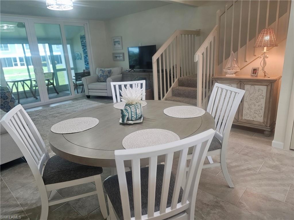Dining room featuring stairway and stone tile flooring