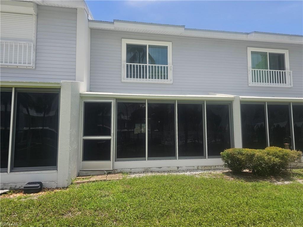 Rear view of property with a yard
