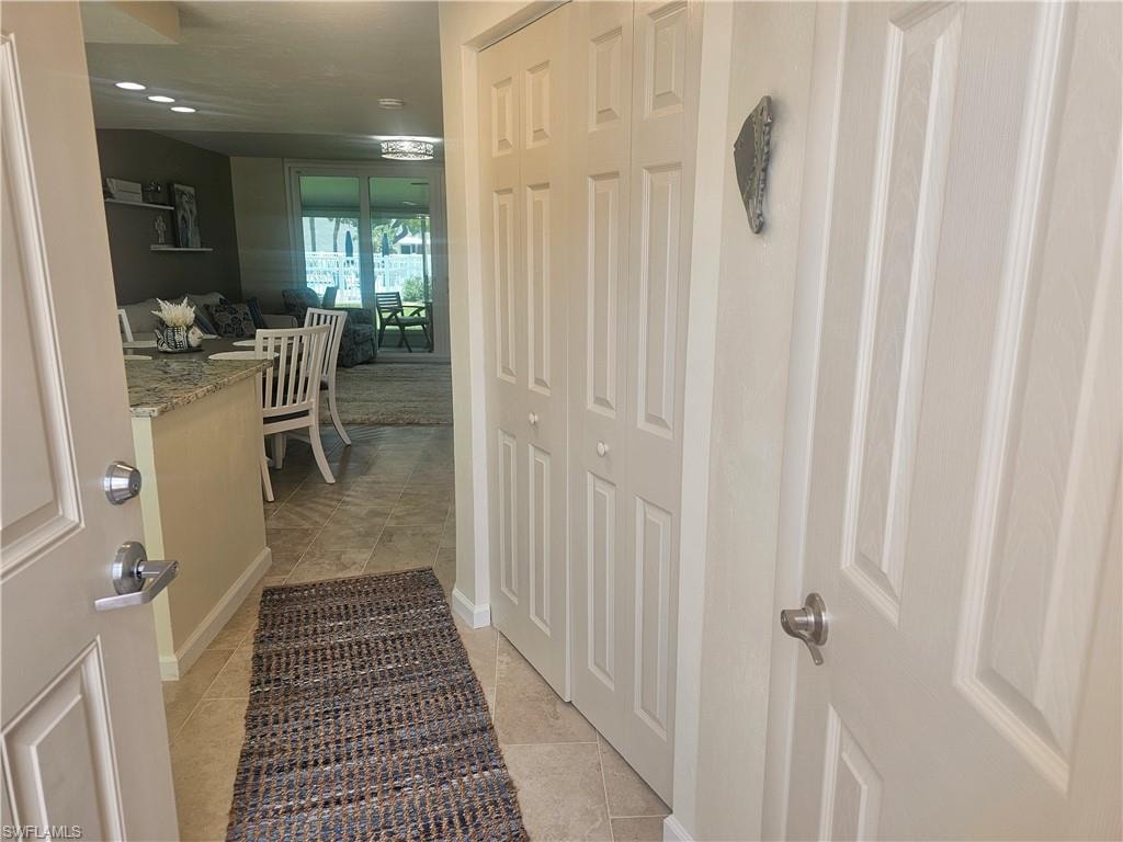 Hallway featuring light tile patterned floors and baseboards