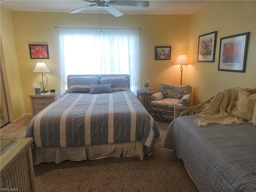Carpeted bedroom featuring a ceiling fan