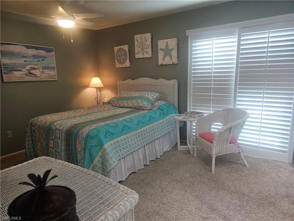Carpeted bedroom featuring a ceiling fan and baseboards