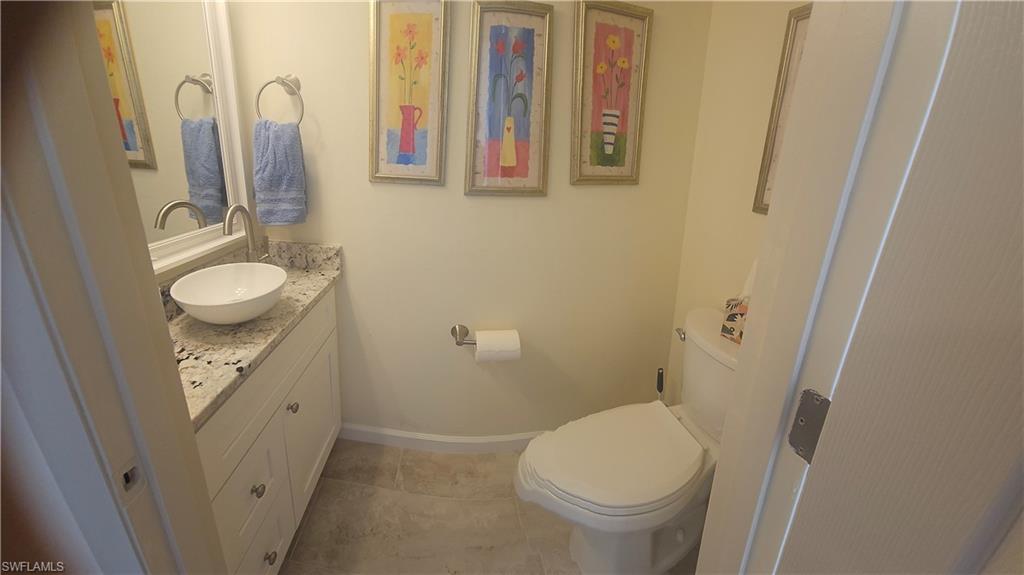 Half bathroom with vanity and tile patterned flooring