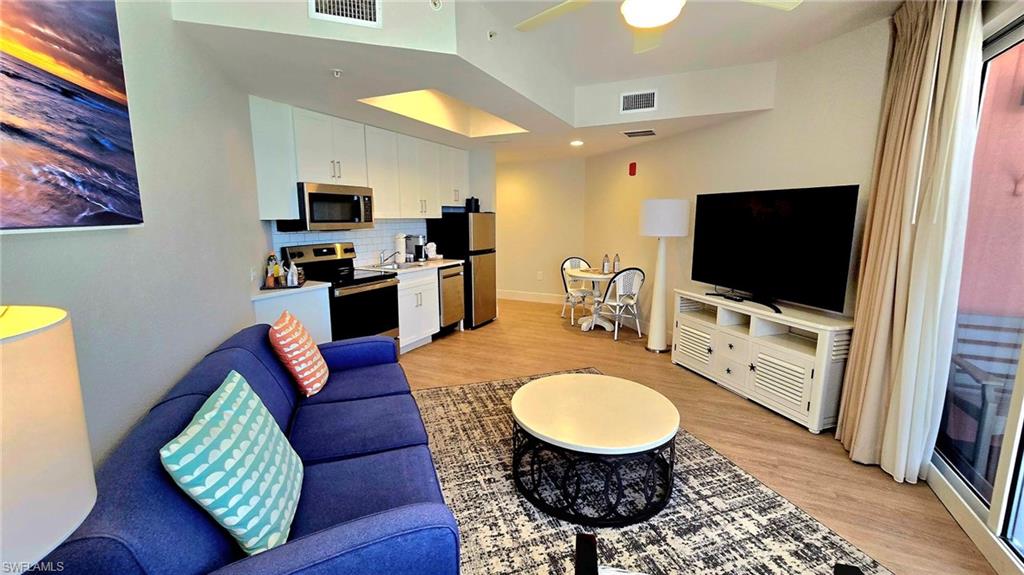 Living area with light wood-type flooring and a ceiling fan