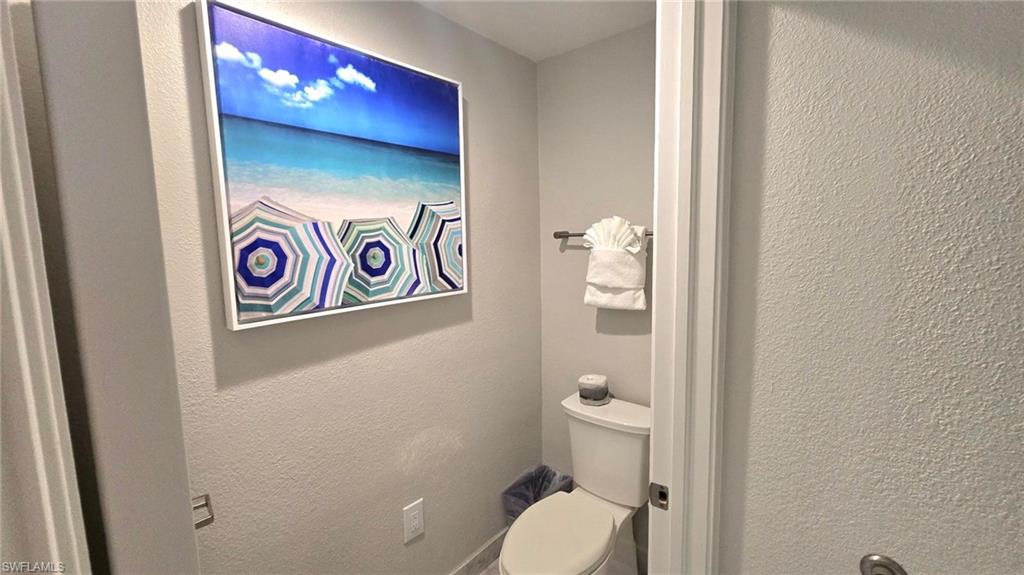 Bathroom with toilet and a textured wall