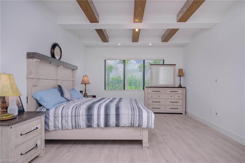 Bedroom featuring beamed ceiling, wood finished floors, and recessed lighting