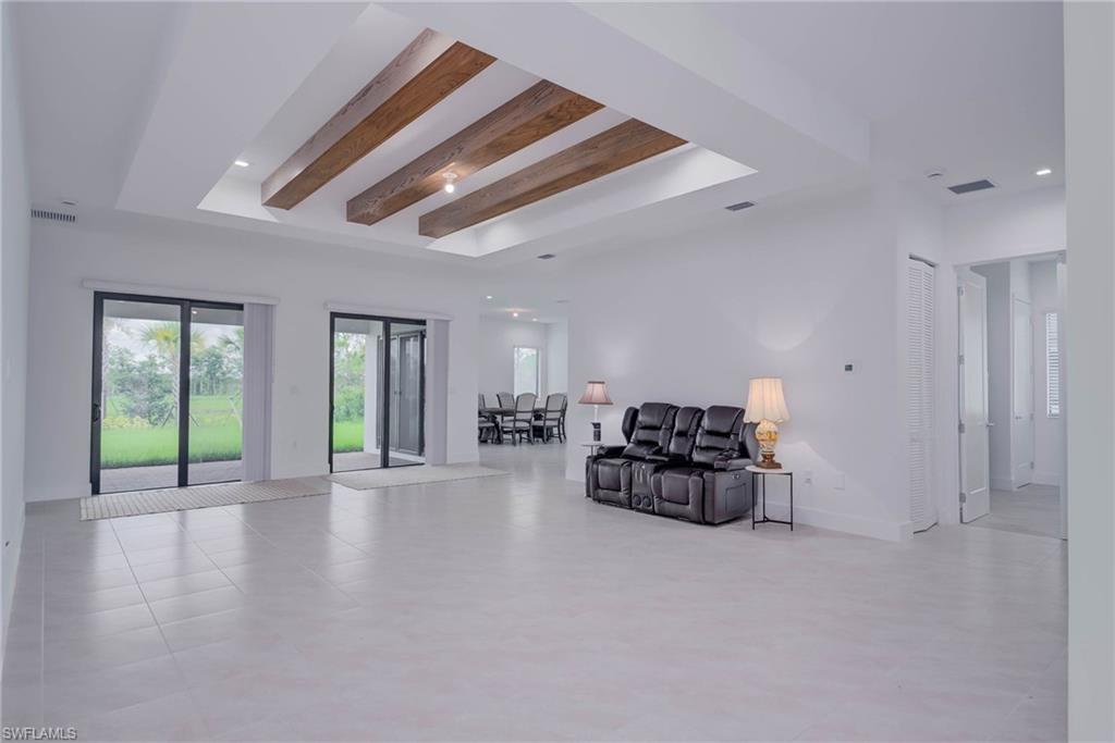 Living area featuring a tray ceiling, recessed lighting, and beamed ceiling