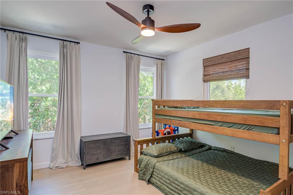 Bedroom with NEW luxury vinyl flooring and a ceiling fan - this bedroom and other bedroom share a bathroom in the hallway