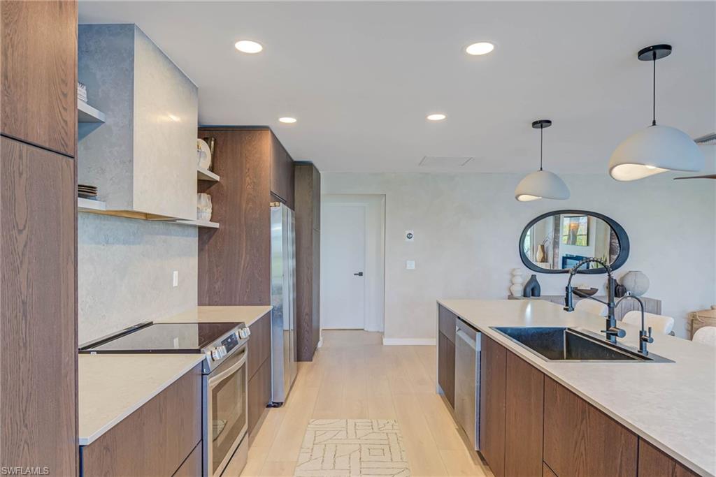 NEWLY REMODELED! Kitchen with stainless stove &  refrigerator, open shelves, modern cabinets, light countertops, and recessed lighting