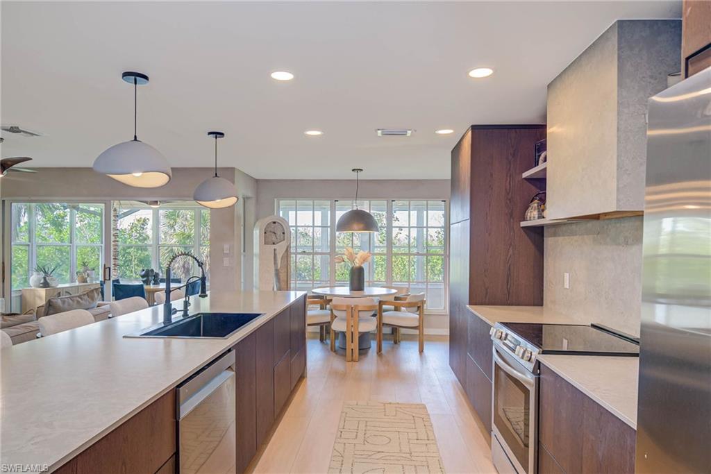 NEWLY REMODELED! Views of the preserve and water! Kitchen with stainless stove &  refrigerator, open shelves, modern cabinets, light countertops, and recessed lighting