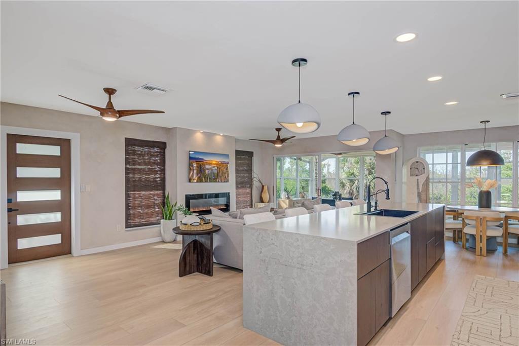 ALL NEW KITCHEN, large island, NEW luxury vinyl plank floors, NEW Impact windows stainless steel dishwasher, a glass covered fireplace, and recessed lighting - access to sunroom with views