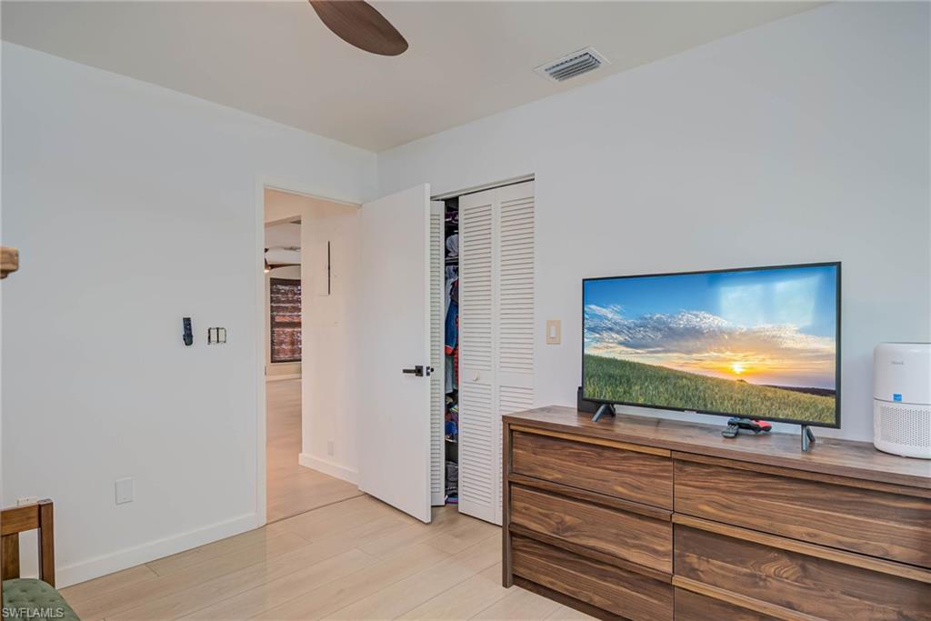 Bedroom featuring NEW luxury vinyl plank, a closet, and ceiling fan- opens to hallway and living area
