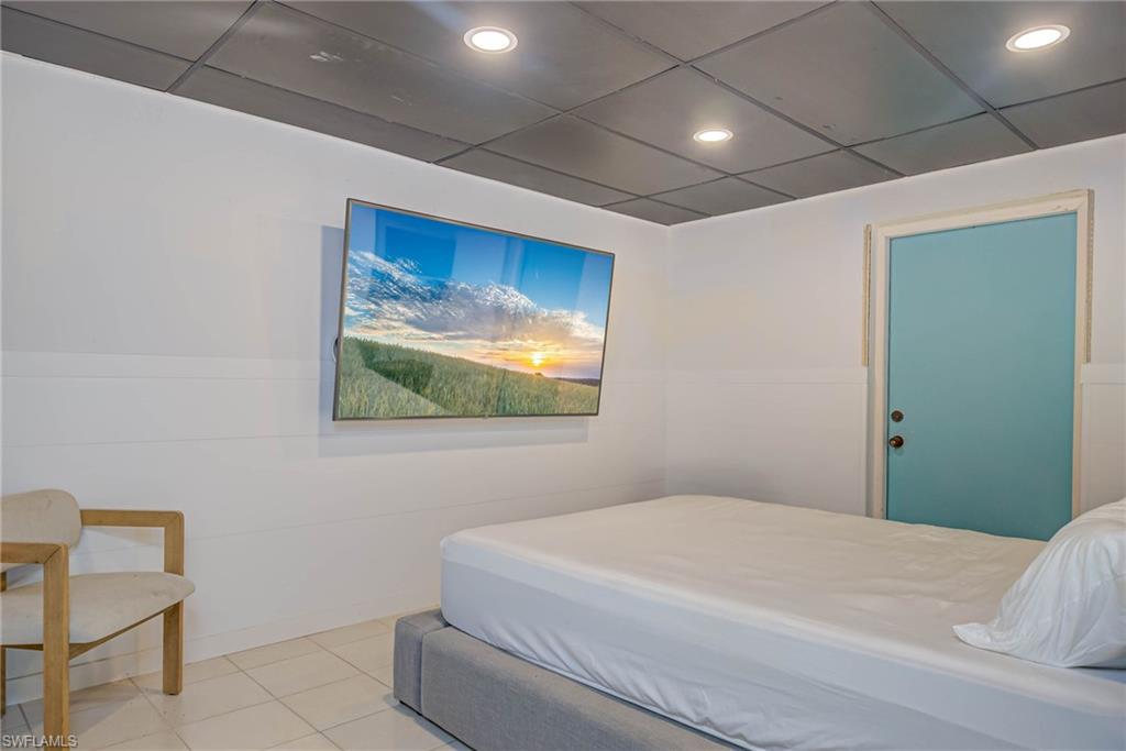 Lower level - Bedroom featuring a paneled ceiling, recessed lighting, and light tile patterned floors