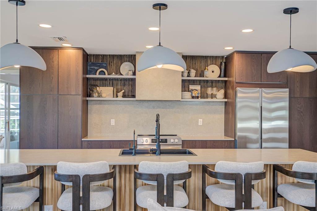 NEWLY REMODELED! Kitchen with stainless stove &  refrigerator, open shelves, modern cabinets, light countertops, and recessed lighting