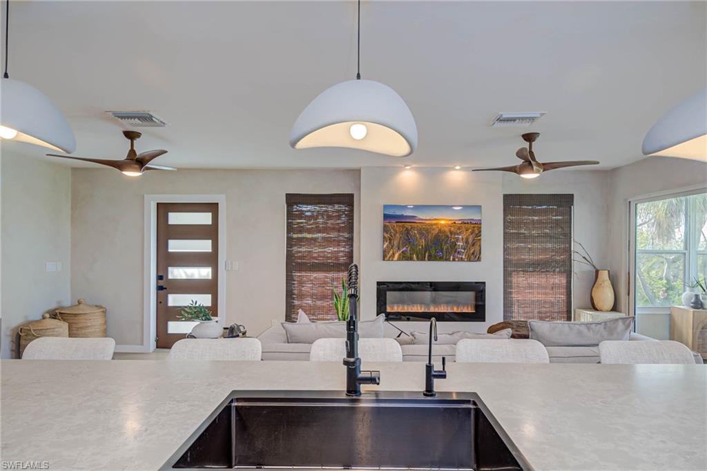 Remodeled Kitchen with ceiling fan, a glass covered fireplace, open floor plan, and pendant lighting. NEW front door!