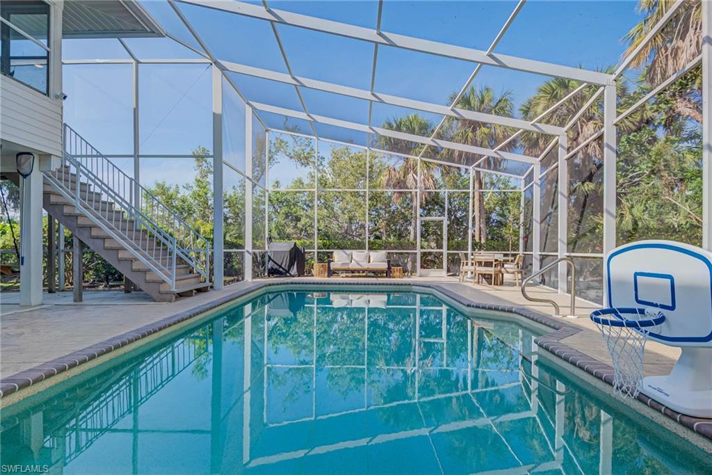 Swimming pool featuring stairs, a long patio area under the house that is shaded and screened-in Fully upgraded pool area with new saltwater pool system, heater, pump, and raised pool equipment. Large screened-in patio area and bonus rooms including bathroom on lower level.
