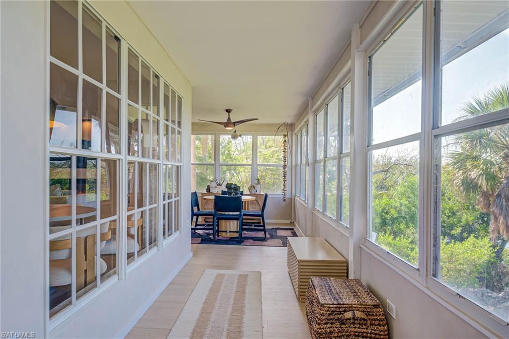 Sunroom featuring a ceiling fan and outdoor dining space on one side and couch and sitting area on the other