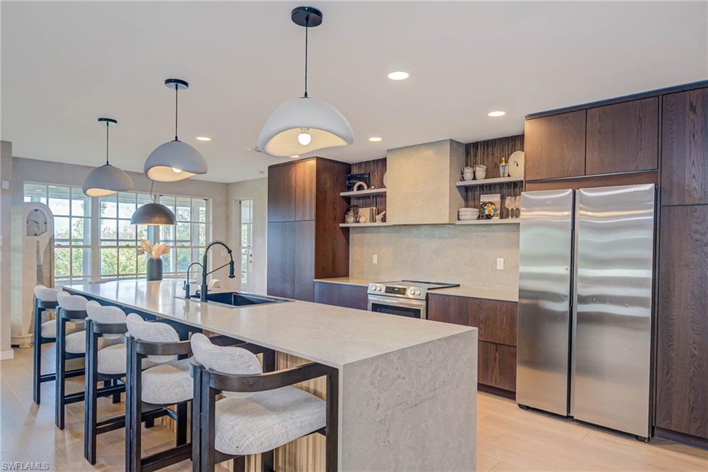 NEWLY REMODELED! Kitchen with stainless stove &  refrigerator, open shelves, modern cabinets, light countertops, and recessed lighting