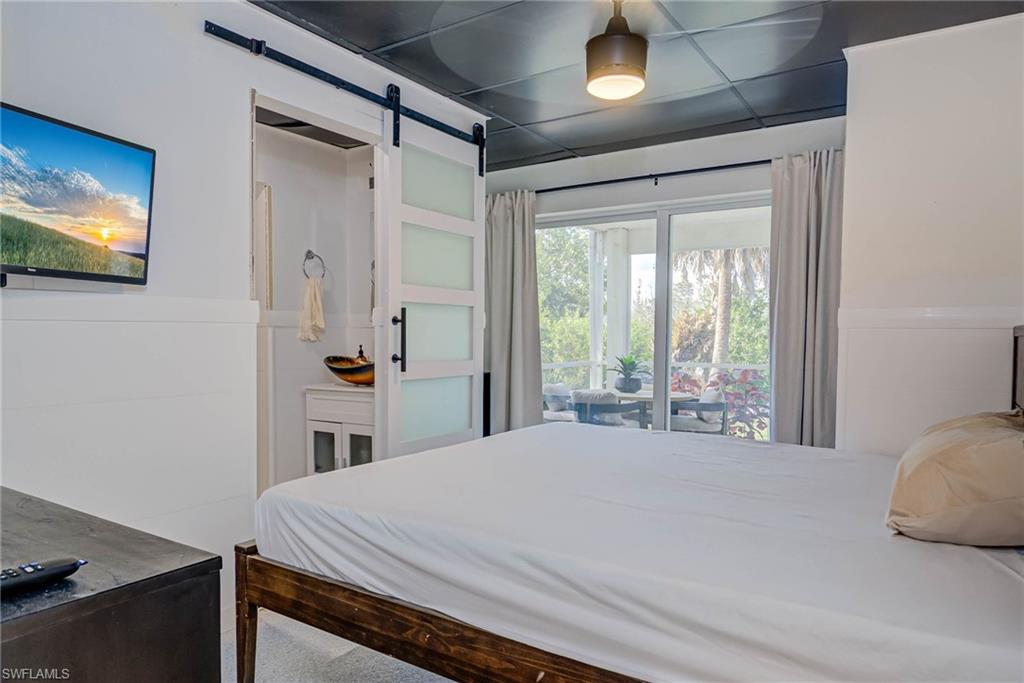 Bonus room- lower level leads to screened-in outside area and pool - barn door to full bathroom