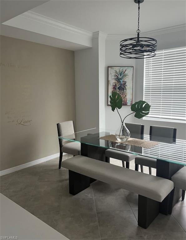 Dining area with ornamental molding and light tile patterned floors