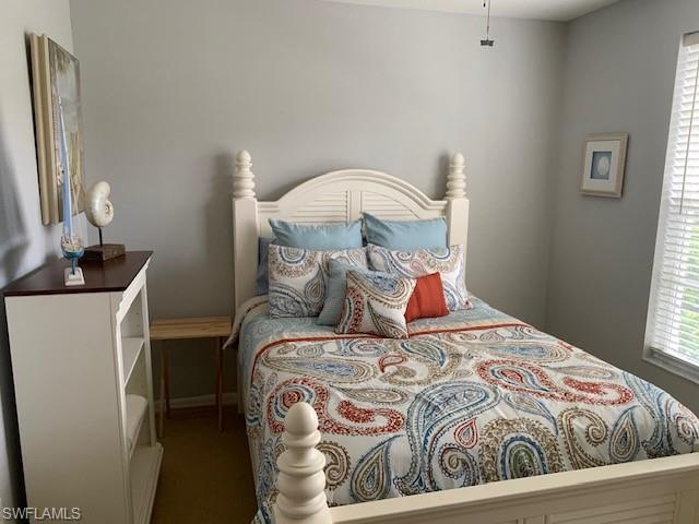 Carpeted bedroom with multiple windows