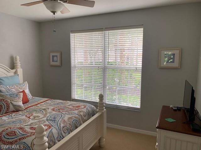 Bedroom with light colored carpet and baseboards