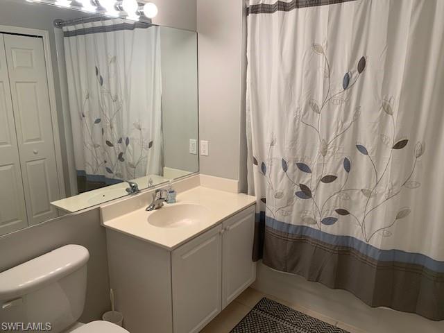 Full bath featuring tile patterned floors, a shower stall, and double vanity