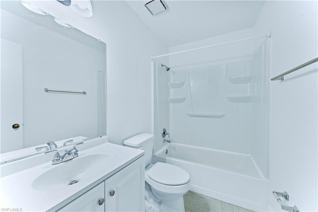 Full bathroom featuring toilet, tub / shower combination, vanity, and tile patterned flooring