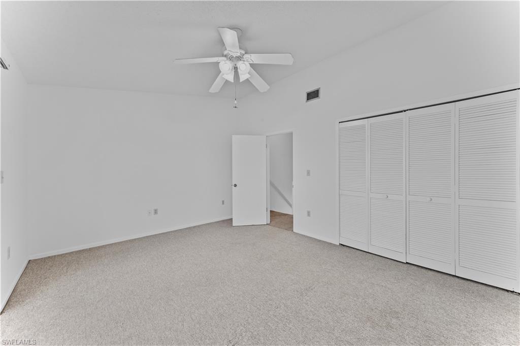 Unfurnished bedroom with light colored carpet, ceiling fan, and a closet