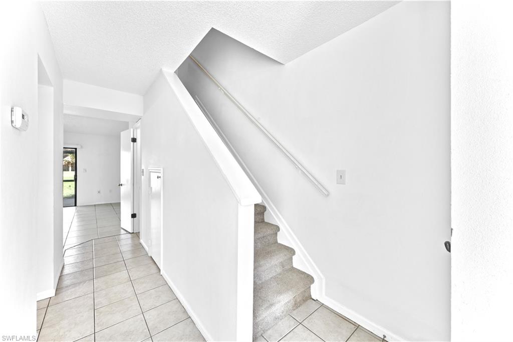 Staircase featuring tile patterned floors and a textured ceiling