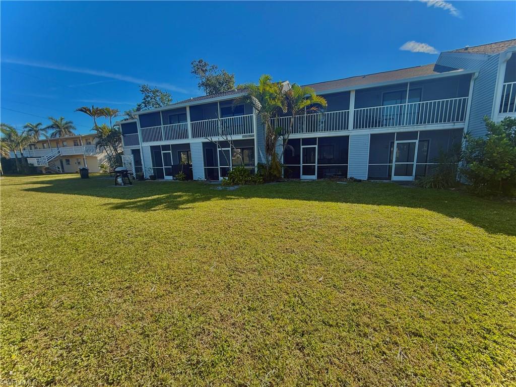 Back of property with a sunroom and a yard