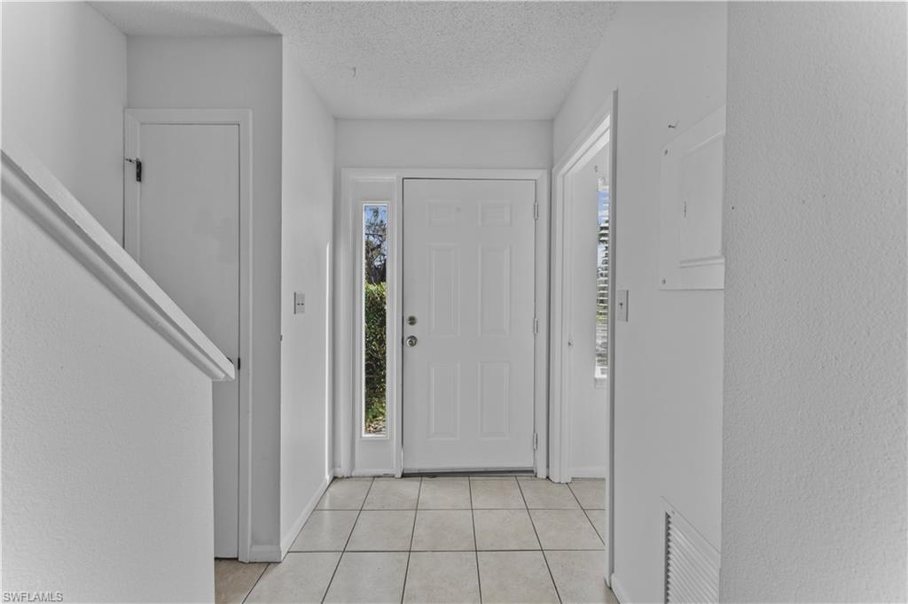 Entrance foyer featuring a textured ceiling and light tile patterned flooring